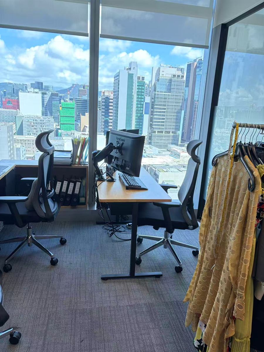 Hong Kong office desk with garment samples and city view